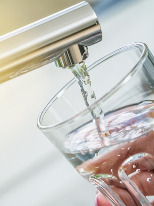 Tapping a glass of water in the kitchen