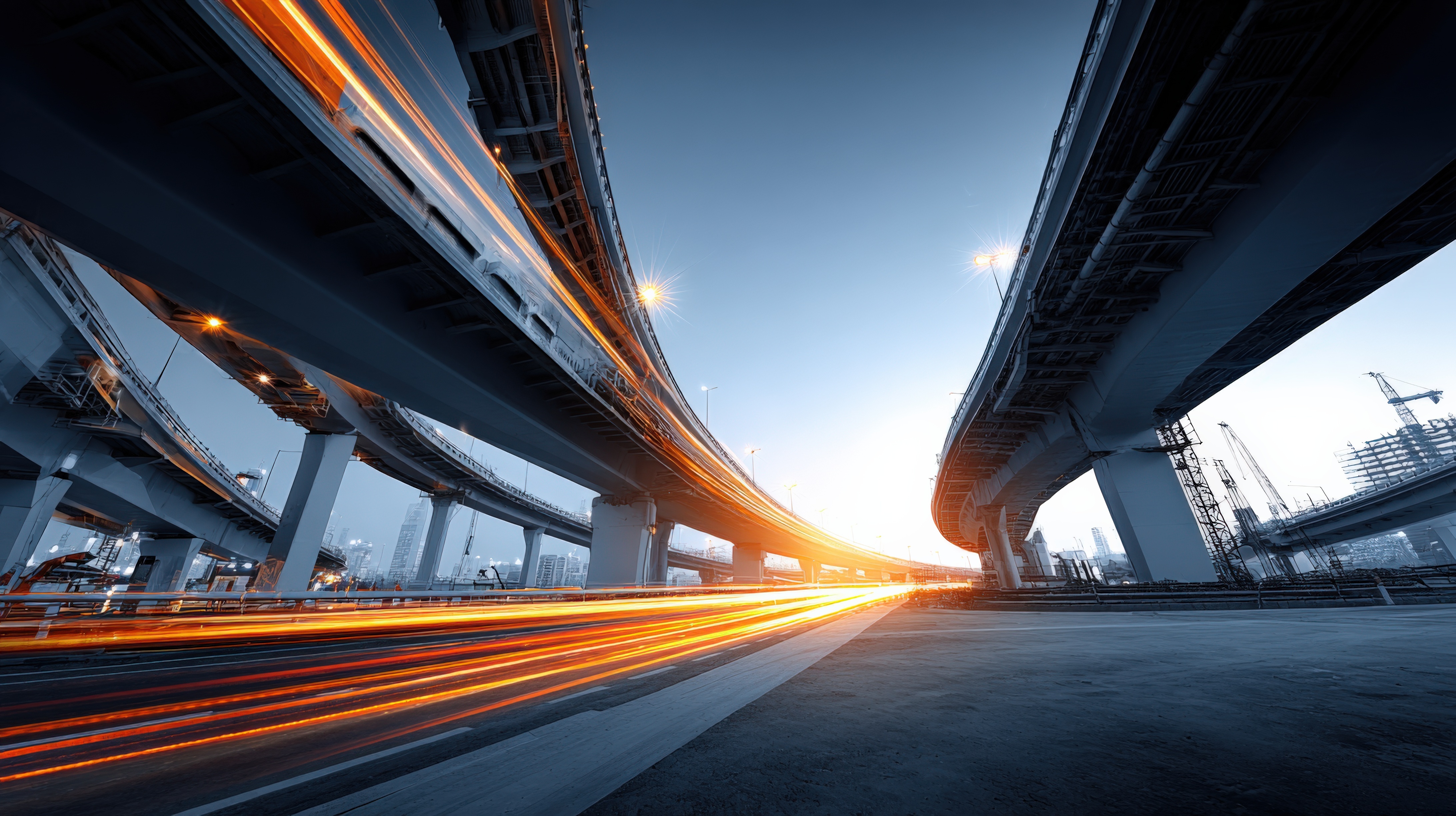 Urban highway interchange at dusk with dynamic light trails, showcasing modern infrastructure and transportation in a metropolitan cityscape.