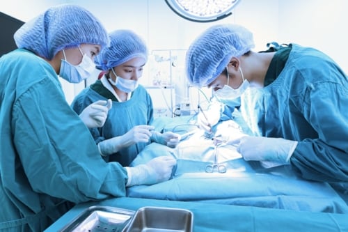 Three doctors performing a surgery