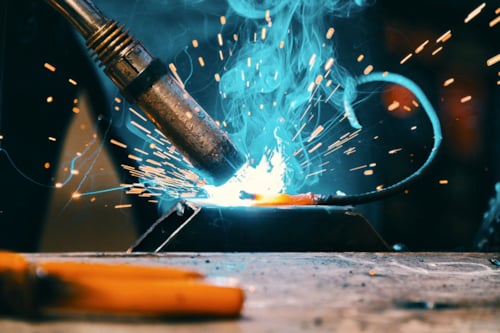 Närbild på svets under svetsarbete, glödgad metall.