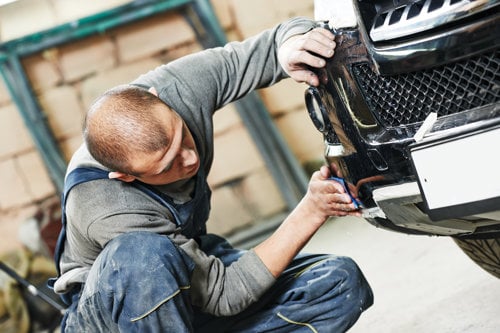 Mechanic working on the front of a car